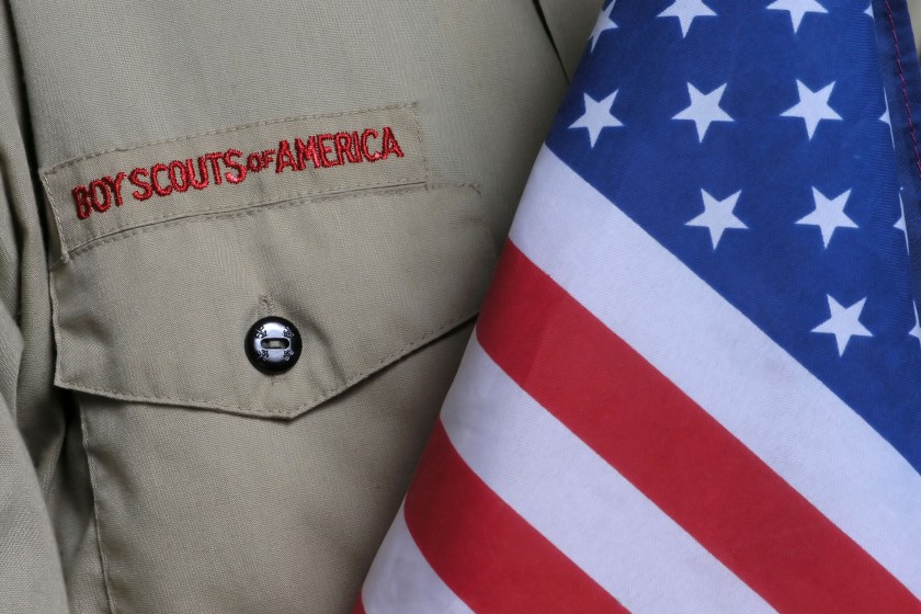 a Boy Scouts of America uniform beside an American flag